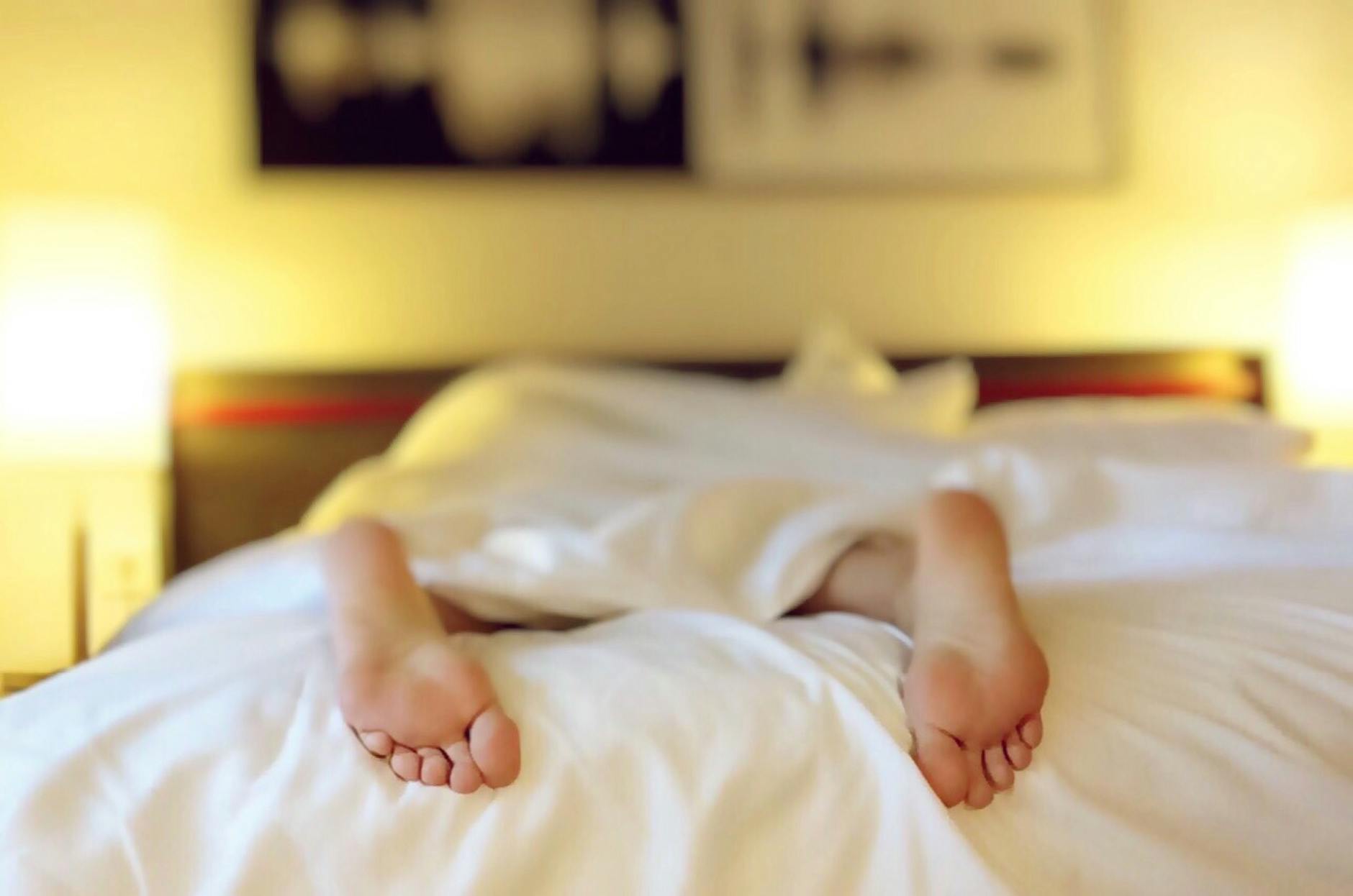 person lying on bed covering white blanket, deep tissue massage recovery
